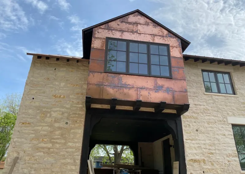 Copper metal panel facade on a stone building for Roof Repair in Kodiak